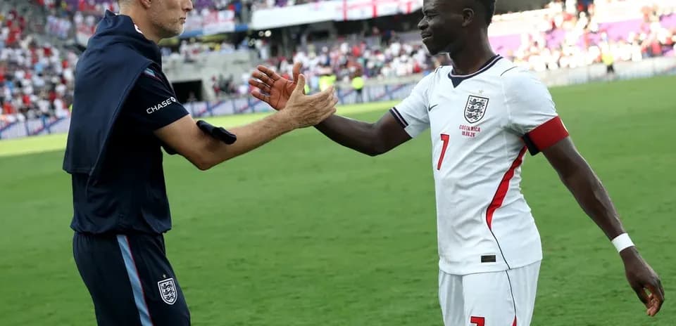 Entrenador y jugador de Inglaterra se saludan en el campo
