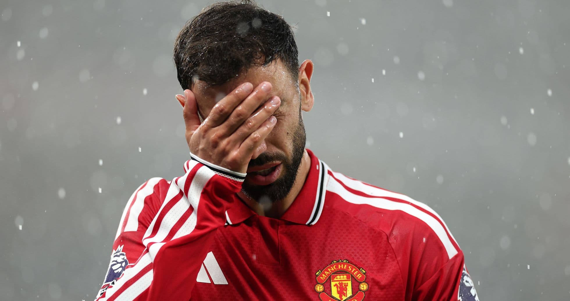 Jugador de Manchester United cubriendo su rostro con la mano