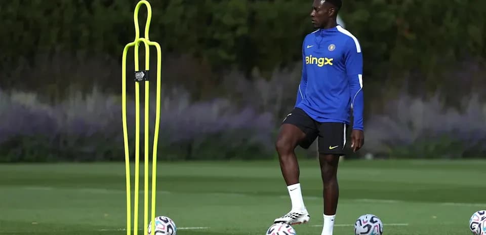 Jugador entrenando junto a conos en el campo