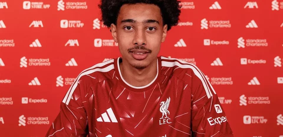 Jugador firmando contrato con camiseta del Liverpool