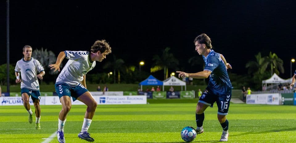 Jugador driblando en partido de fútbol