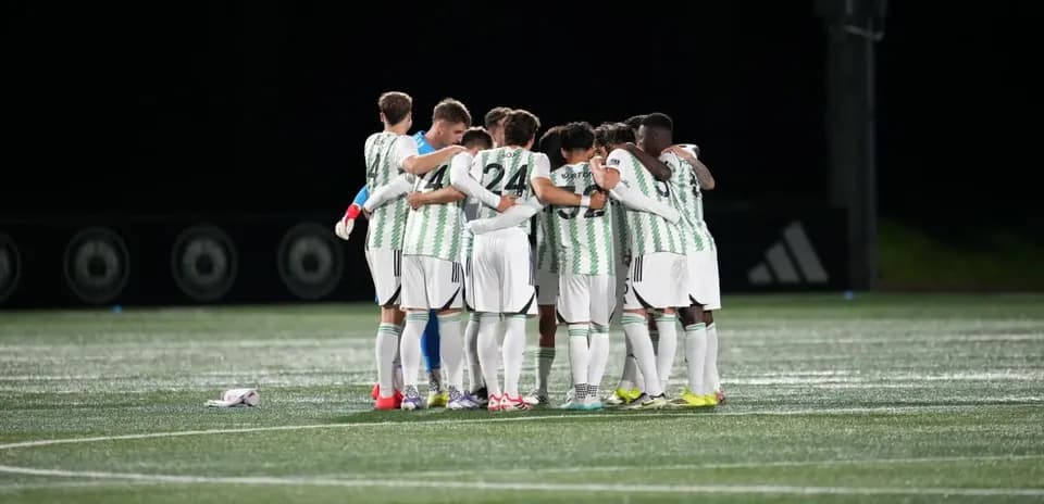 Equipo de fútbol en círculo durante calentamiento
