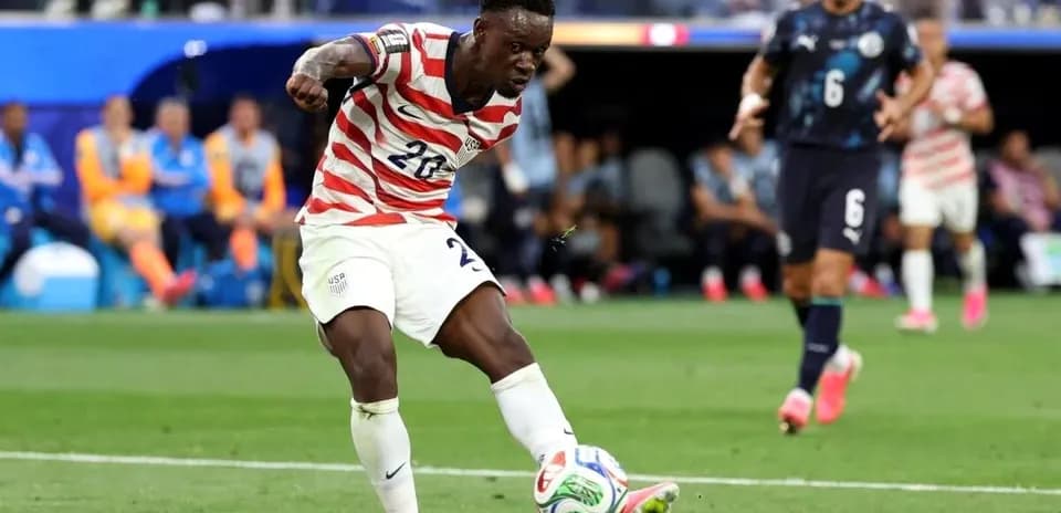 Jugador de Estados Unidos disparando el balón en partido