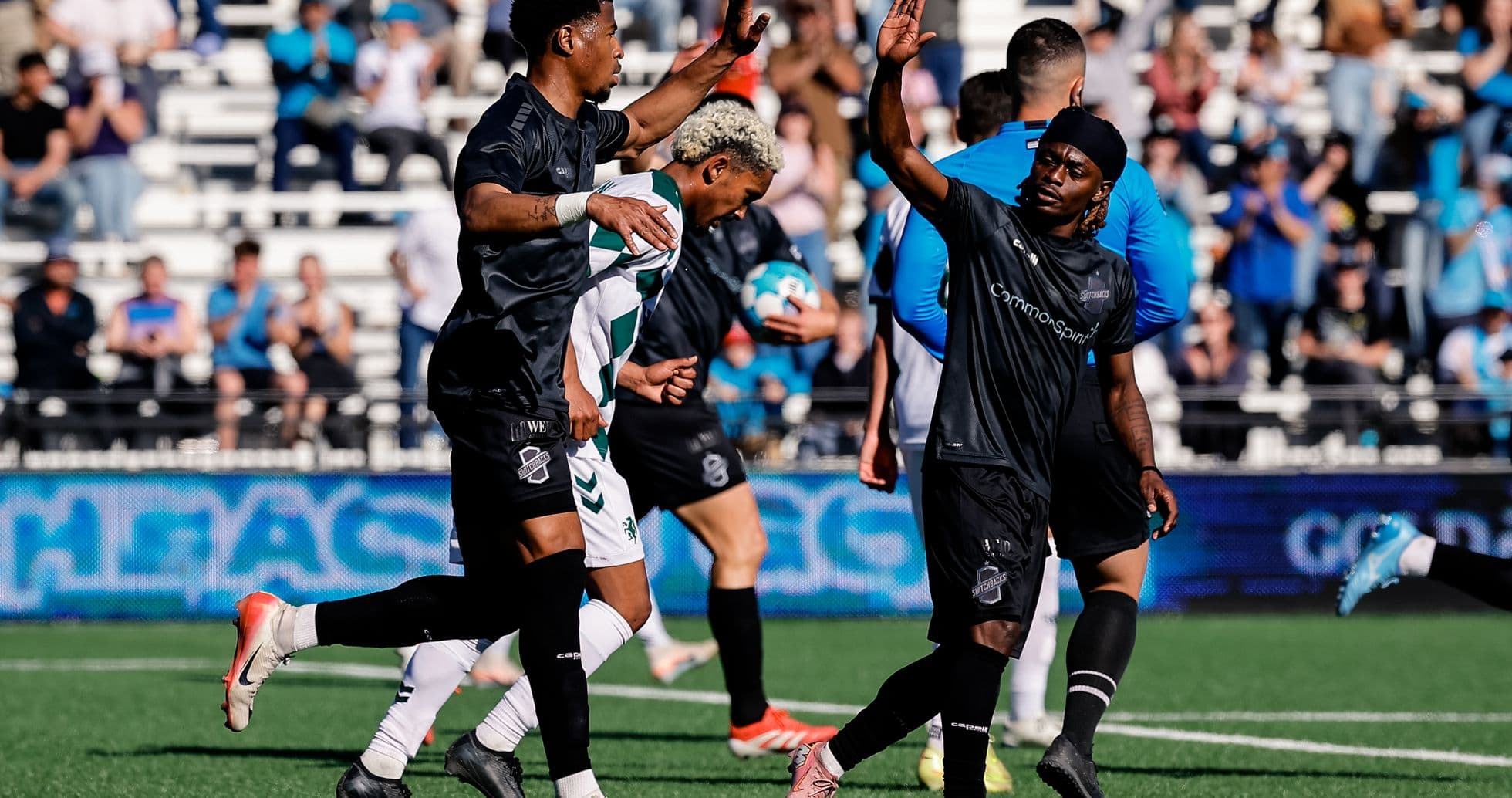 Jugadores saludando durante el partido de fútbol