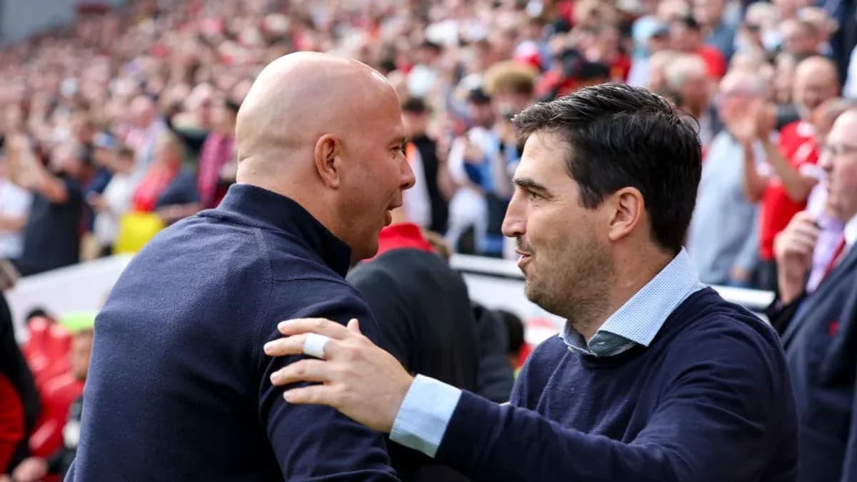 Entrenadores saludándose en el estadio durante partido
