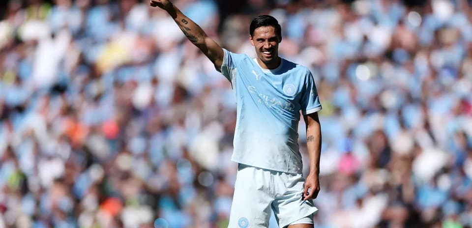 Jugador de Manchester City señalando a la afición