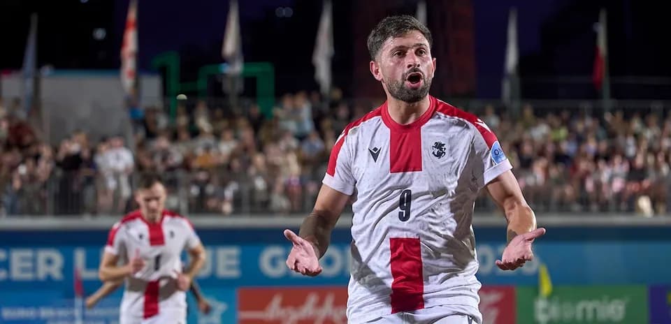 Jugador con camiseta blanca y roja protestando en el campo