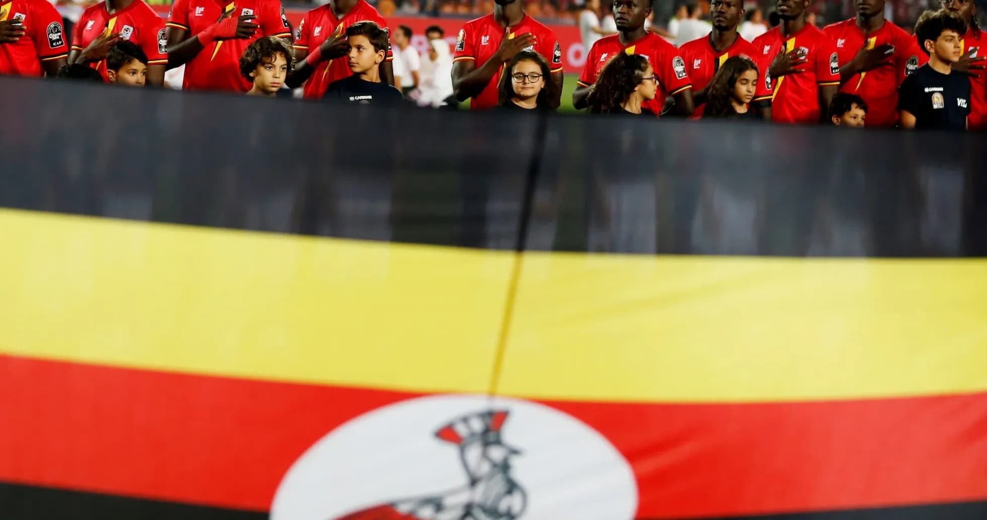 Jugadores de Uganda con la bandera nacional en el fondo