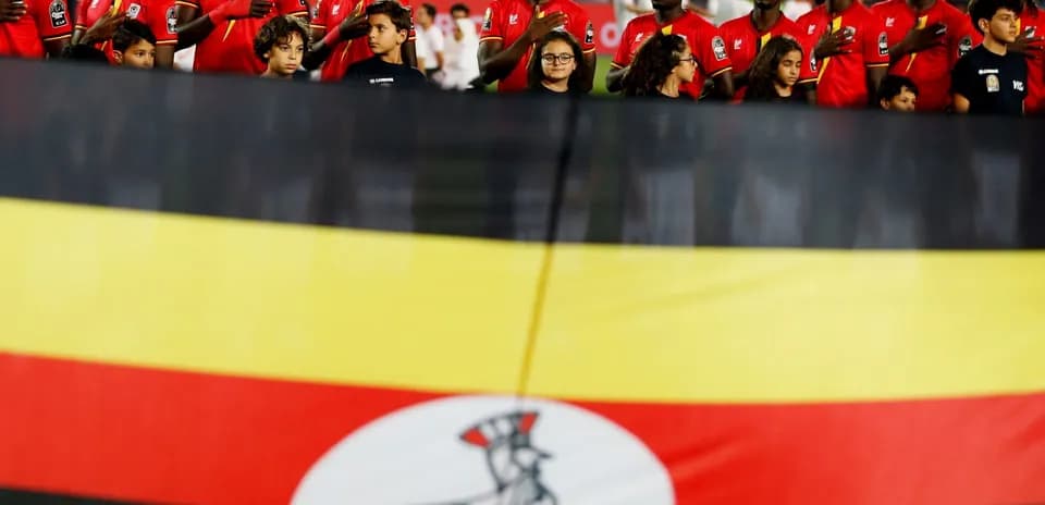 Jugadores de Uganda con la bandera nacional en el fondo