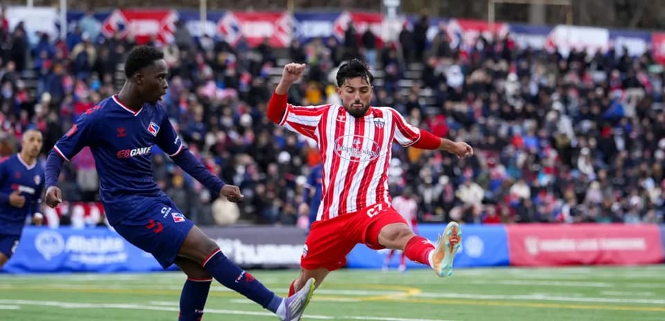 Dos jugadores compitiendo en el partido de fútbol