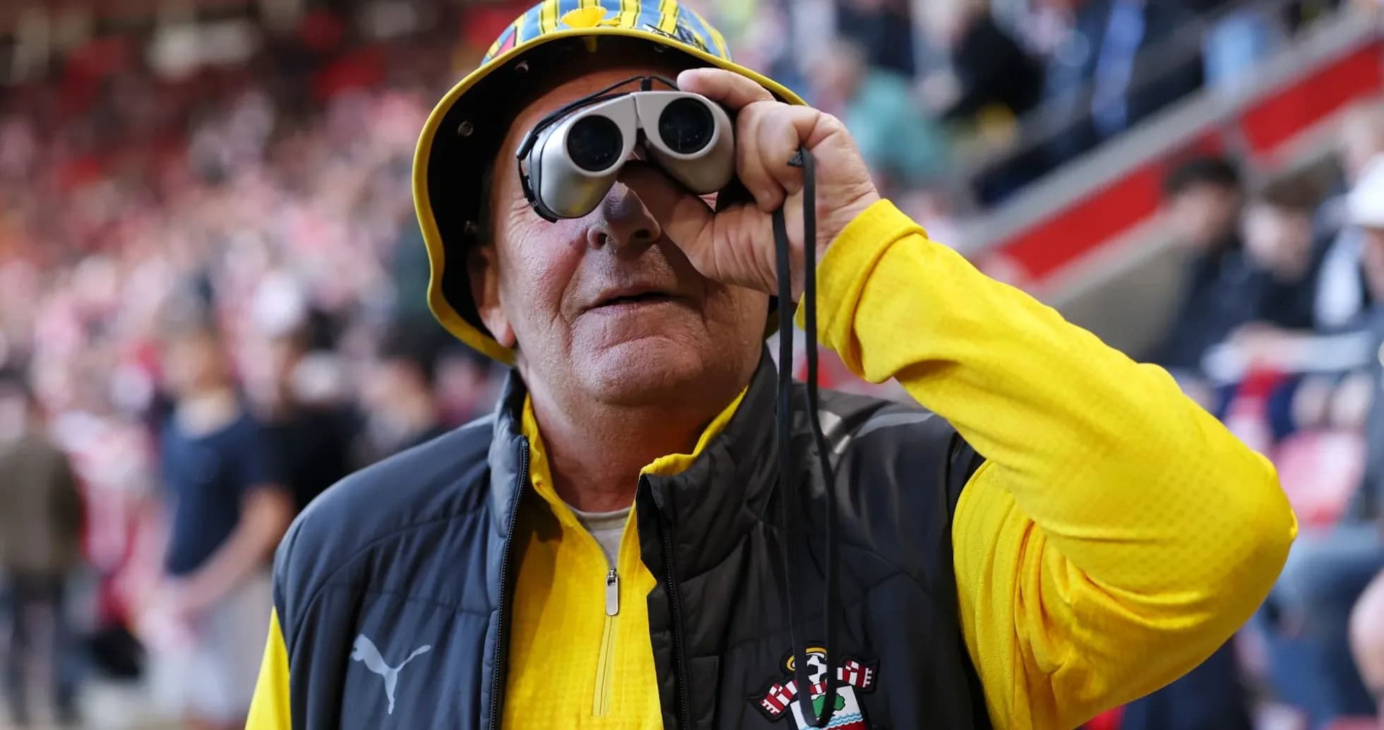 A fan wearing binoculars at a football match