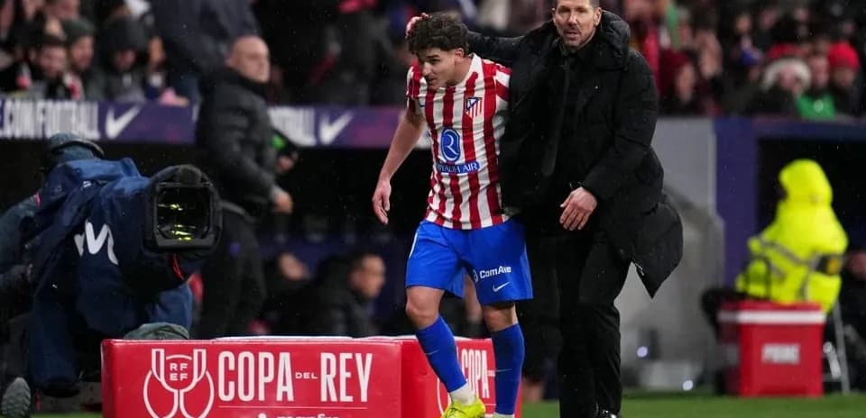 Entrenador asistiendo a jugador en la banda