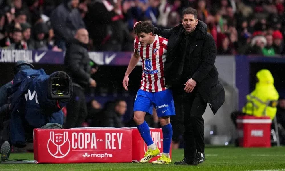 Entrenador asistiendo a jugador en la banda