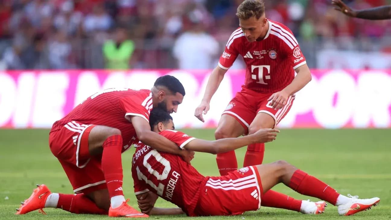 Jugadores de Bayern Munich ayudando a Musiala en el campo