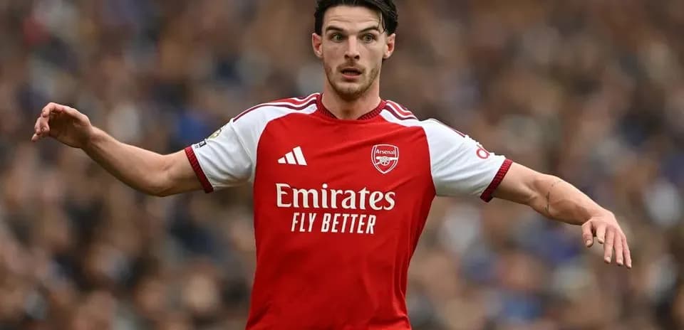 Jugador de Arsenal corriendo con balón en el campo