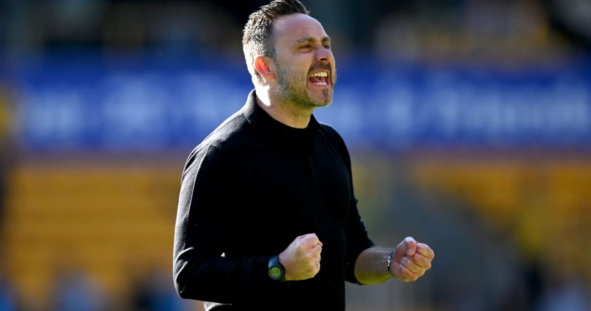 Entrenador celebrando con puños apretados en el campo