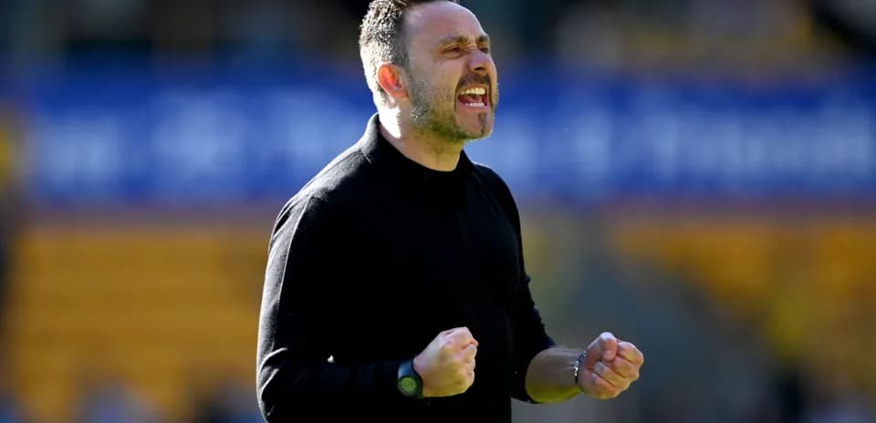 Entrenador celebrando con puños apretados en el campo