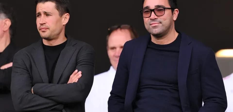 Dos hombres observando un evento deportivo desde la tribuna