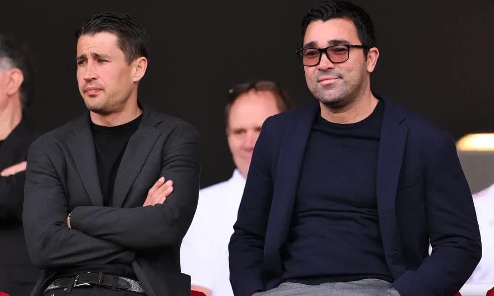 Dos hombres observando un evento deportivo desde la tribuna