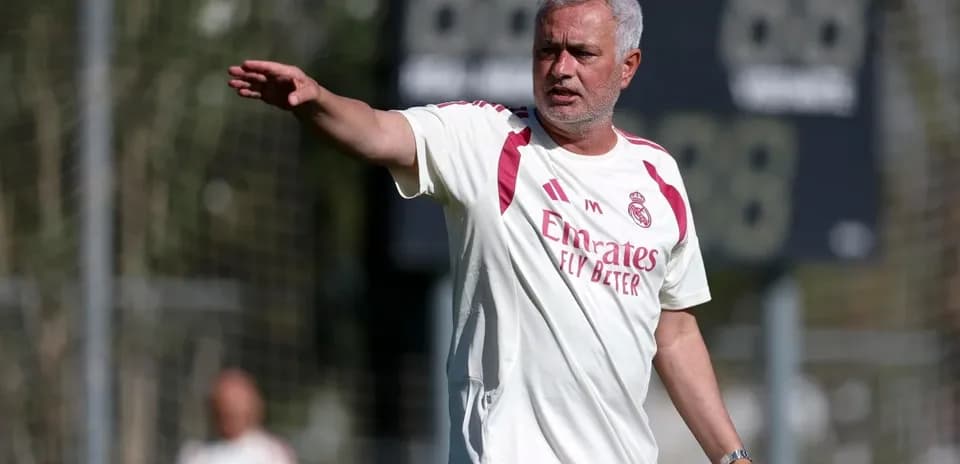 Entrenador dirigiendo a jugadores en campo de entrenamiento