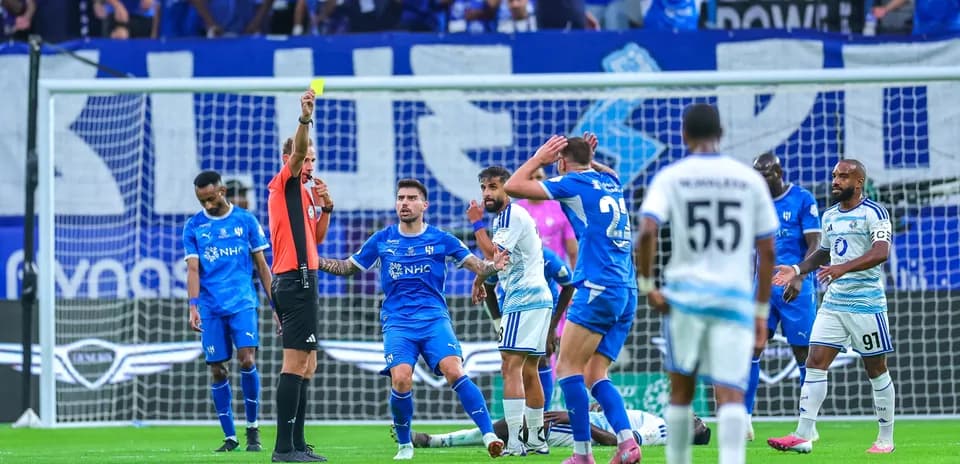 Árbitro mostrando tarjeta amarilla a jugador durante partido