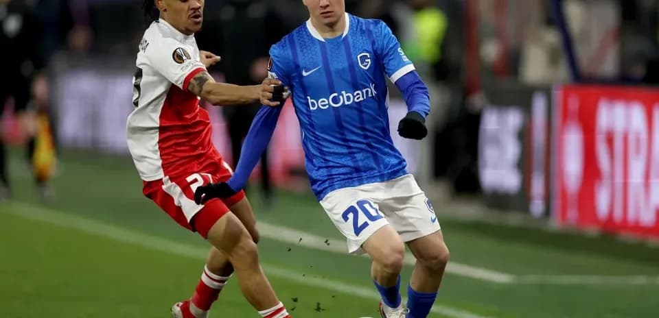 Jugador de Genk driblando mientras es marcado