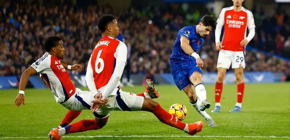 Jugador de Chelsea disparando ante dos defensores de Arsenal
