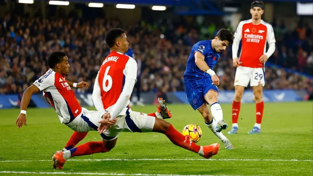 Jugador de Chelsea disparando ante dos defensores de Arsenal