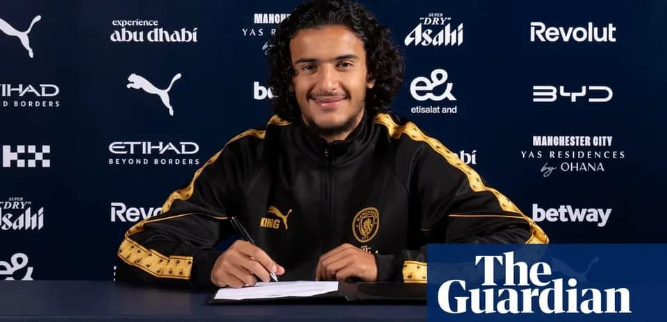 Jugador firmando contrato en mesa con logotipos de patrocinadores