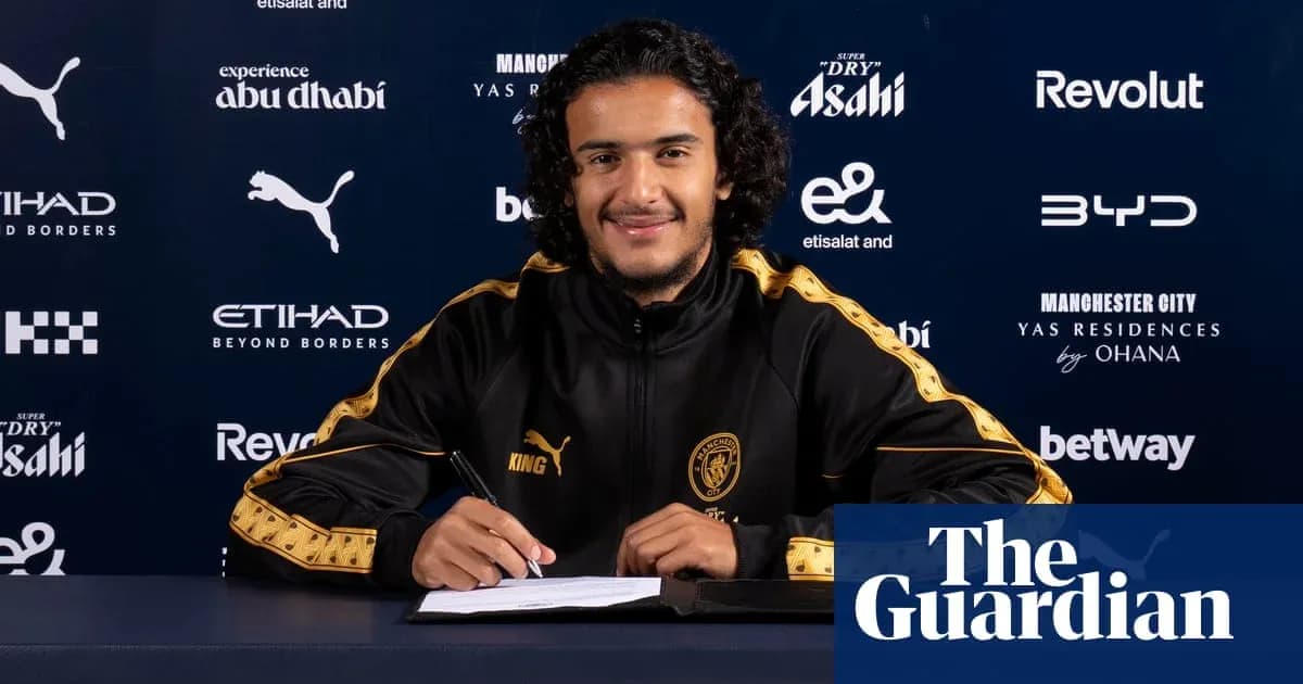 Jugador firmando contrato en mesa con logotipos de patrocinadores