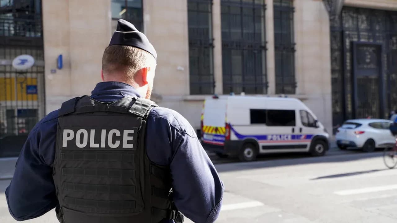 Policía de espaldas frente a furgón policial