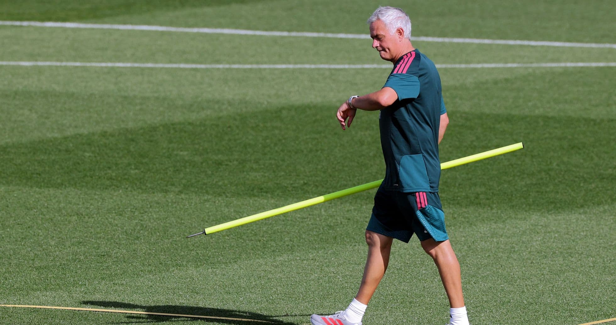 Entrenador caminando con un palo de entrenamiento