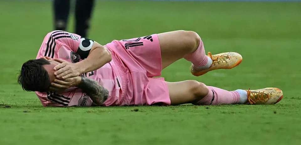 Jugador caído en el campo sosteniéndose la cabeza