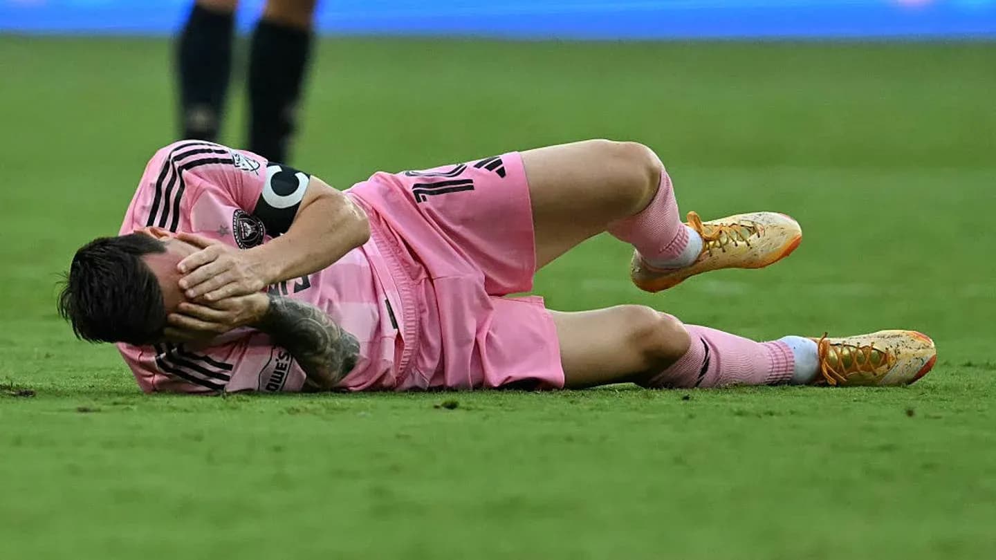 Jugador caído en el campo sosteniéndose la cabeza