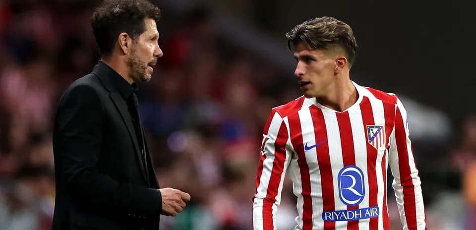 Entrenador y jugador conversando en el campo