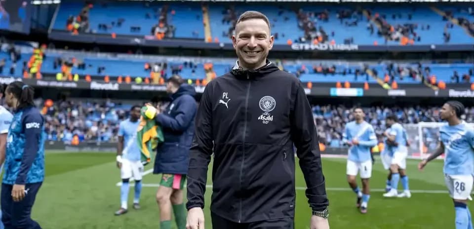 Entrenador sonriendo al final del partido en el estadio