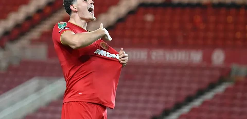 Jugador celebrando y levantando la camiseta en el estadio
