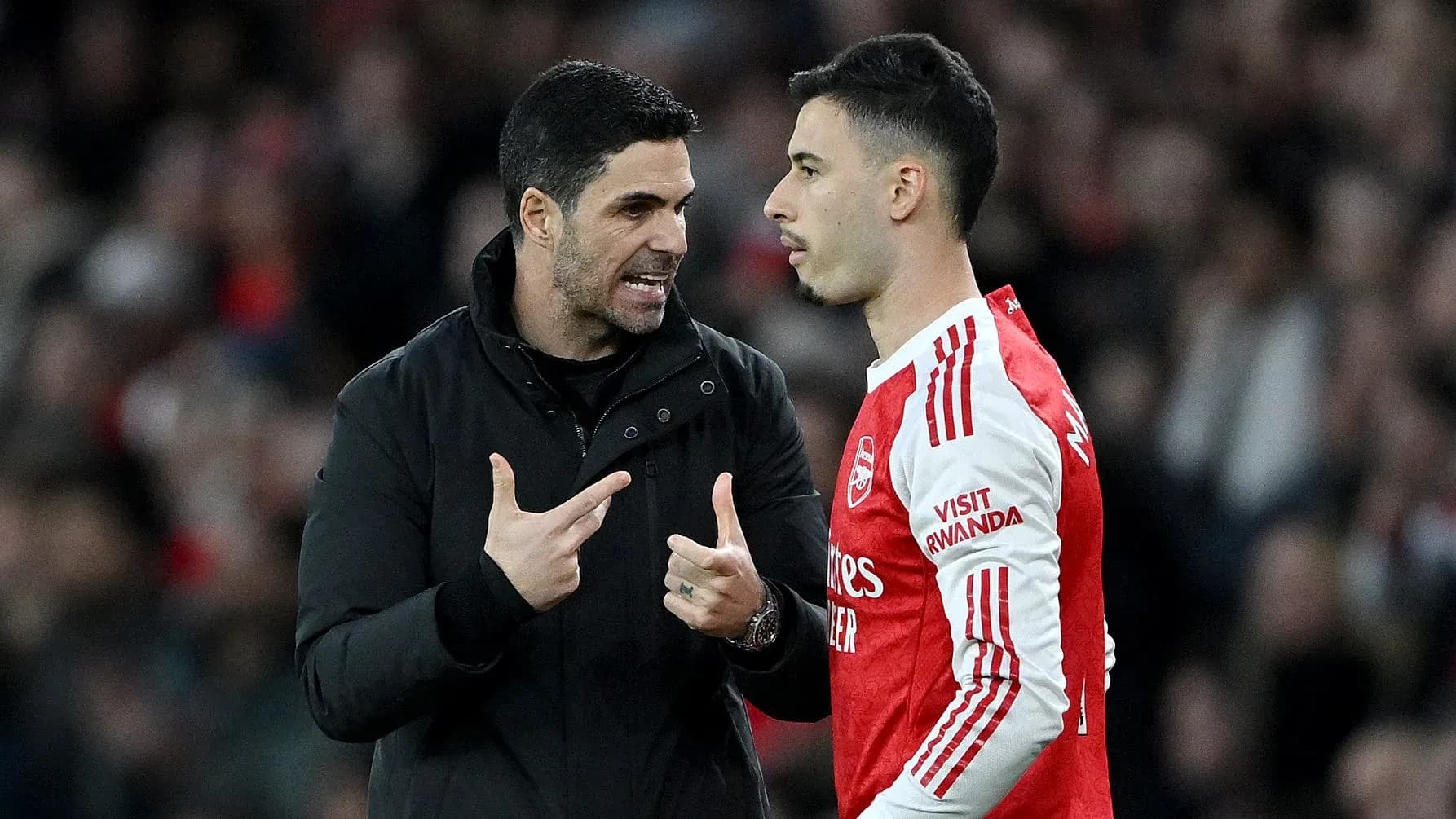 Entrenador hablando con jugador en el banquillo