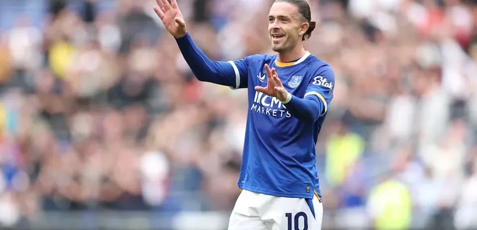 Jugador de fútbol saludando con camiseta azul