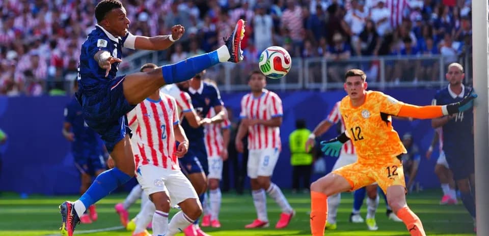 Jugador rematando mientras el portero observa