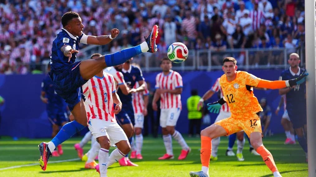 Jugador rematando mientras el portero observa
