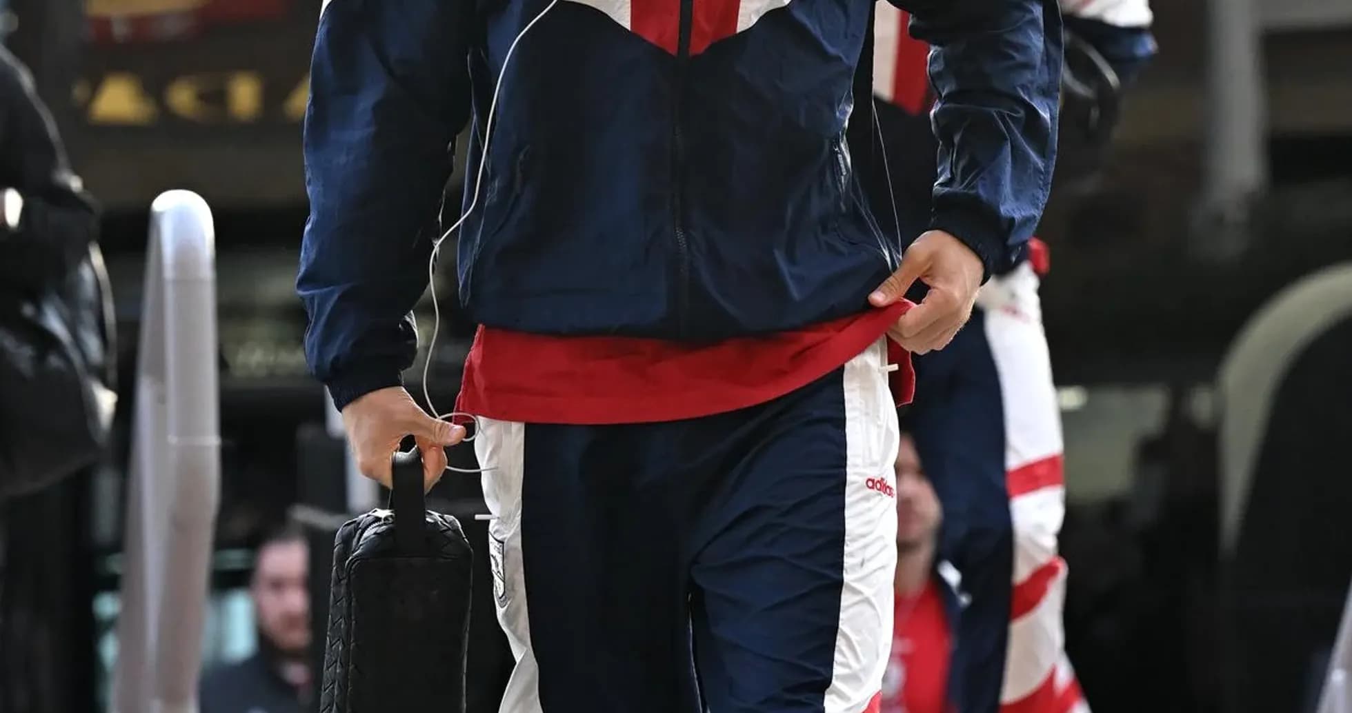 Jugador entrando con chándal y maletín