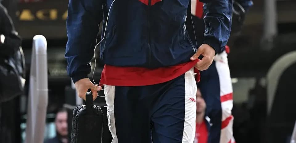 Jugador entrando con chándal y maletín