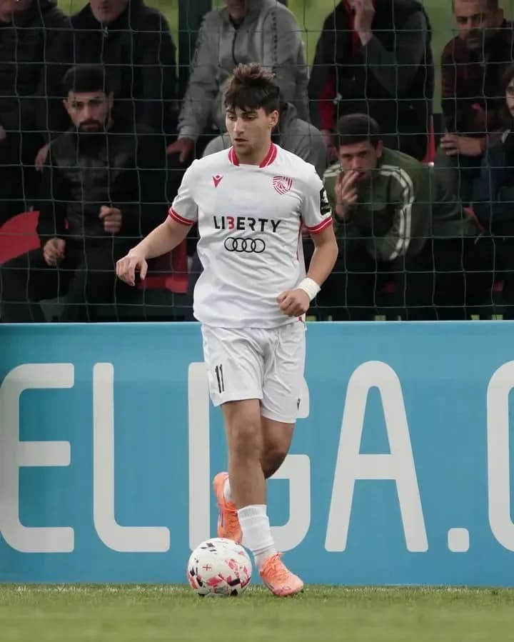 Jugador con balón durante partido de fútbol