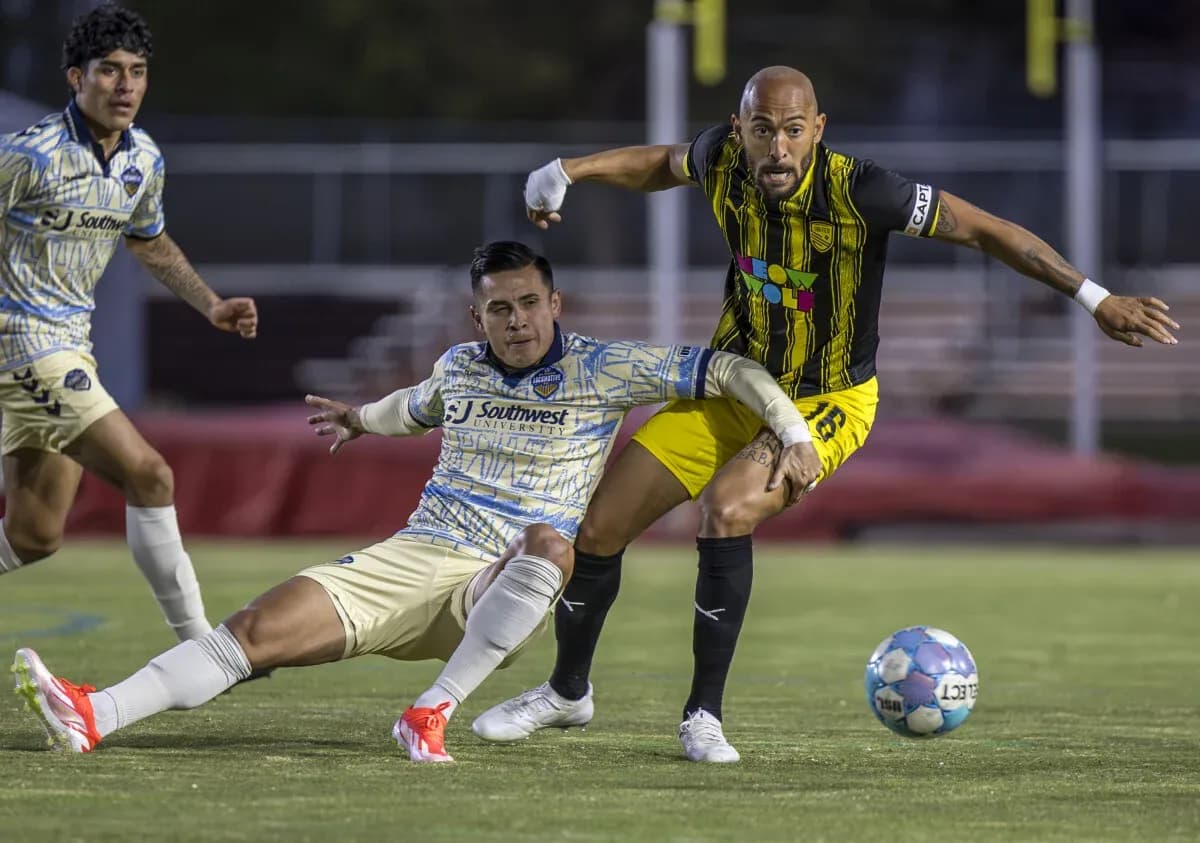 Jugadores compitiendo por el balón en el partido