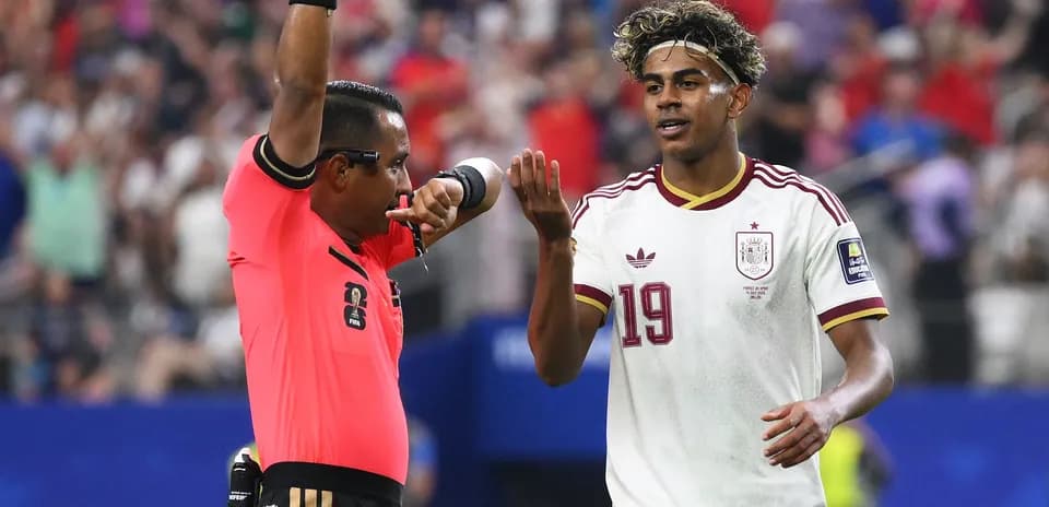 Árbitro amonestando a jugador durante partido de fútbol