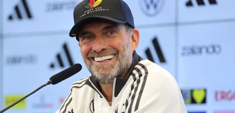 Entrenador sonriendo en conferencia de prensa