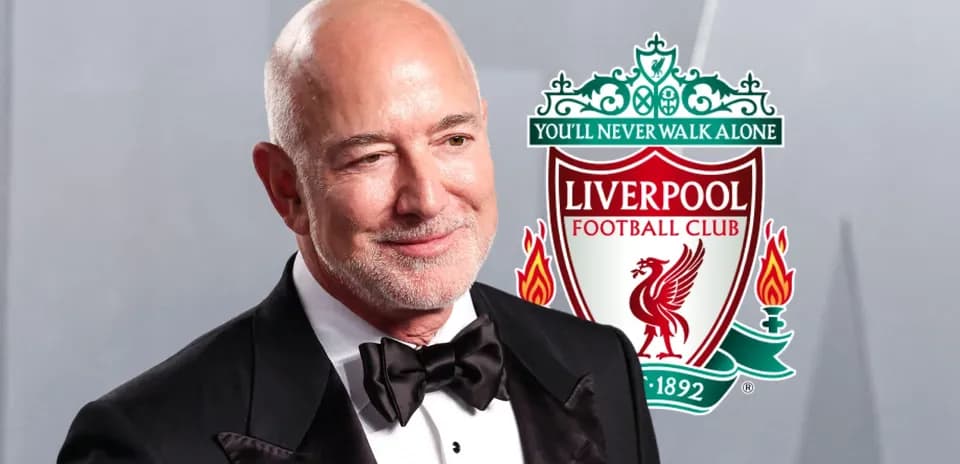 Hombre en traje con escudo de Liverpool detrás