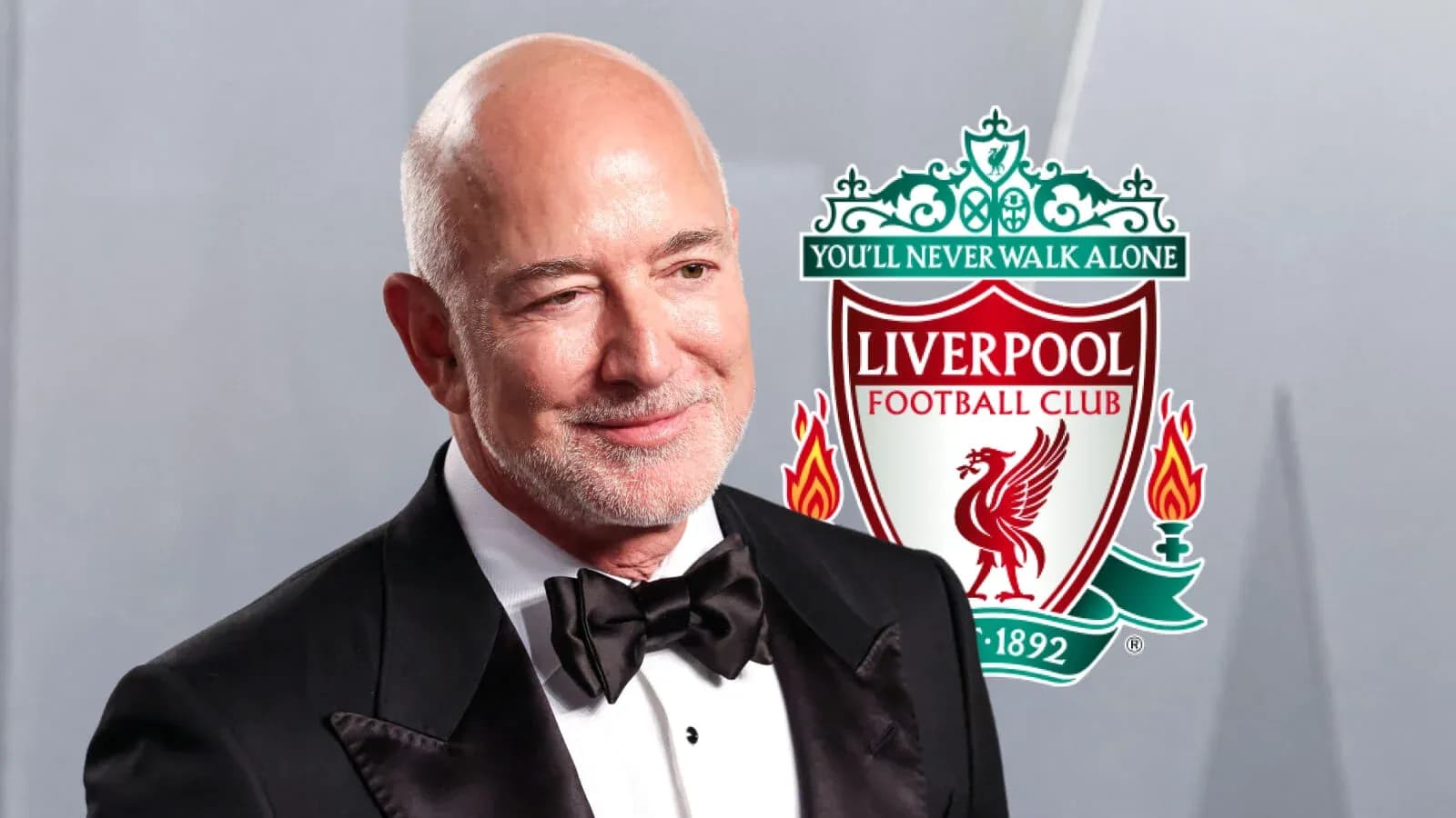Hombre en traje con escudo de Liverpool detrás