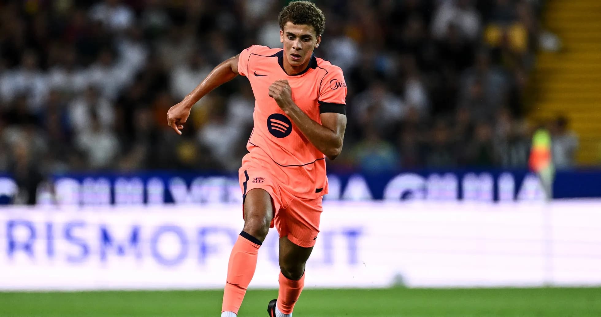 Jugador corriendo en camiseta naranja durante partido